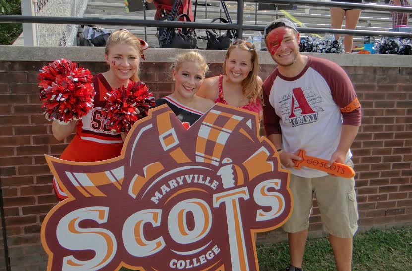 (L to R) Brandi Berghorn, Summer LeCain, Emily Ramsey, and Spencer Blanden use the Loud Scotsmen's Scots cut out to show off their school spirit at half time on September 27th. Photo Courtesy of Candace Whitman