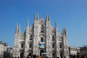 Milan Cathedral, located in central Milan, Italy. featuring a banner advertising a visit from the Pope.