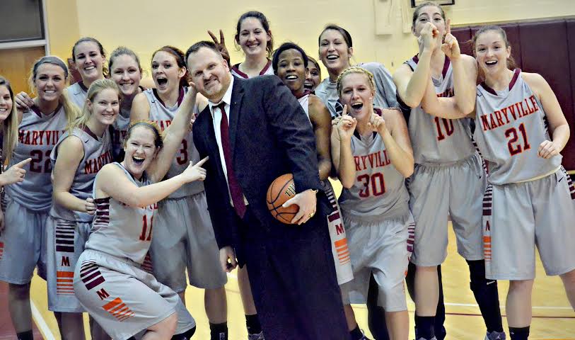 Head coach Darrin Travilian celebrates his 100th career victory with his team, while junior guard Joanna Young gives him ‘bunny ears.’ The Scots are now 13-1 and ranked no. 22 in the nation according to d3hoops.com. Photo Courtesy of Beth Murphy.