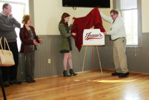 Alicia Yarlett ‘18 and James Dulin of Metz Culinary Management unveil the new Isaac’s logo during a ceremony. Photo courtesy of MC Communications.