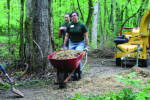 Rachel Weaver and Bailey Kitts help with renovating a trail in the Maryville College woods.