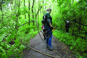 Hannah Kirby stands with pruners as she and other Maryville College students clear the trail.